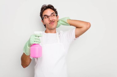 Beyaz arka planda izole edilmiş genç İspanyol adam kafasının arkasına dokunuyor, düşünüyor ve bir seçim yapıyor..