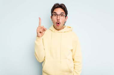 Mavi arka planda izole edilmiş genç bir İspanyol ağzı açık bir şekilde üst tarafı işaret ediyor..