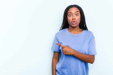 Saçları örülmüş genç Afrikalı Amerikalı bir kadın. Mavi arka planda izole edilmiş.