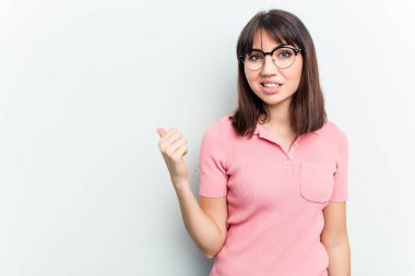 Beyaz arka planda izole edilmiş genç beyaz kadın işaret parmağıyla fotokopi alanını işaret ederek şok oldu..