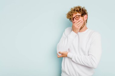 Kafkasyalı genç adam mavi arka planda yalnızdı gülerek, kaygısızca, doğal duygularla.