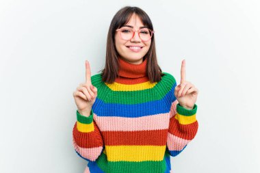 Beyaz arka planda izole edilmiş genç beyaz kadın iki parmağı da boş bir alan gösteriyor..