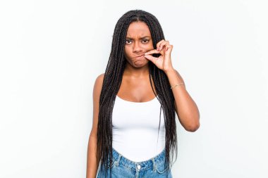 Genç Afrikalı Amerikalı kadın beyaz arka planda izole edilmiş, parmakları dudaklarında bir sır saklıyor..