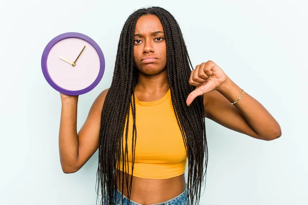 Ung Afroamerikansk Kvinna Håller Klocka Isolerad Blå Bakgrund Visar Motbjudande — Stockfoto