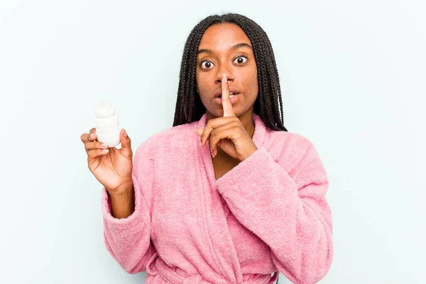 Młoda Afroamerykanka Szlafroku Trzymająca Dezodorant Odizolowany Niebieskim Tle Trzymająca Sekret — Zdjęcie stockowe