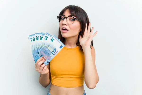 Young Caucasian Woman Holding Banknotes Isolated Blue Background Trying Listening — Stock Photo, Image