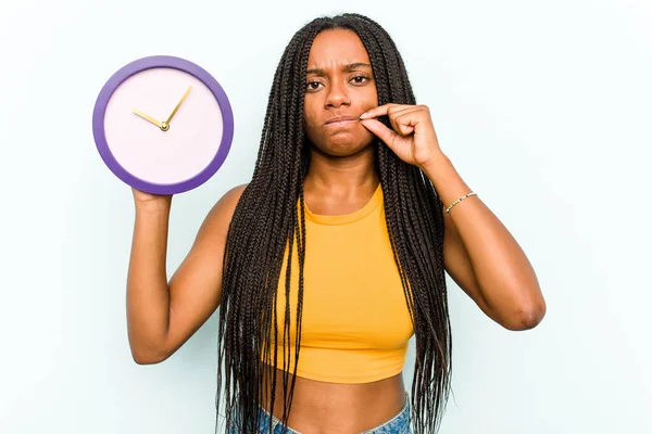 Ung Afroamerikansk Kvinna Håller Klocka Isolerad Blå Bakgrund Med Fingrar — Stockfoto