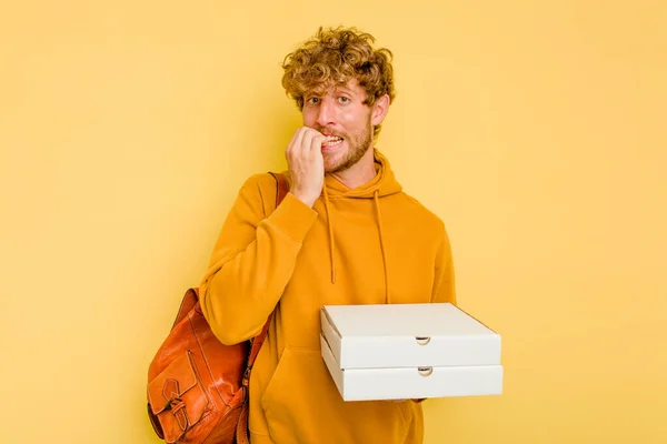 Mladý Student Muž Drží Pizzy Izolované Žlutém Pozadí Kousání Nehty — Stock fotografie
