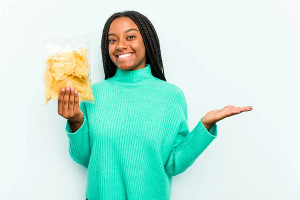 Jovem Afro Americana Segurando Batatas Fritas Isoladas Fundo Azul Mostrando — Fotografia de Stock