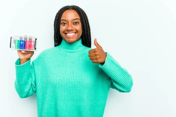 年轻的非洲裔美国女人拿着电池盒 带着蓝色背景 面带微笑 竖起大拇指 — 图库照片