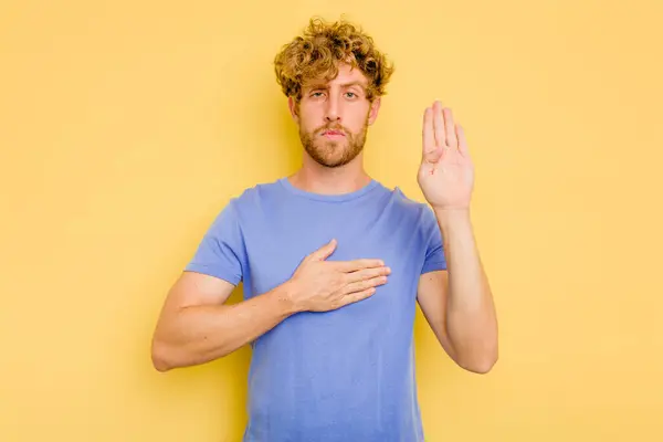 Young Caucasian Man Isolated Yellow Background Taking Oath Putting Hand — Stock Photo, Image