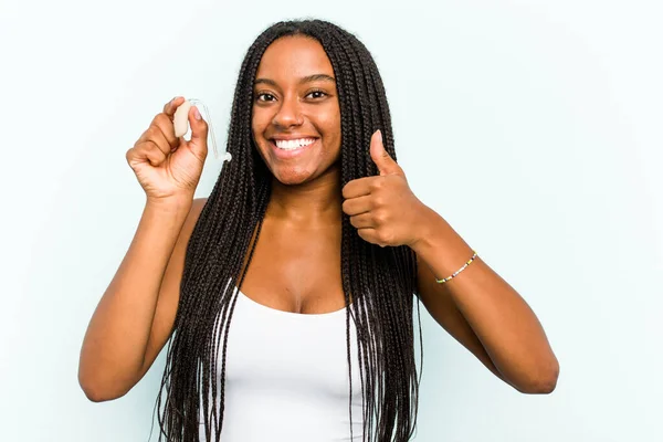 Young African American Woman Holding Hearing Aid Isolated Blue Background — Stock Photo, Image