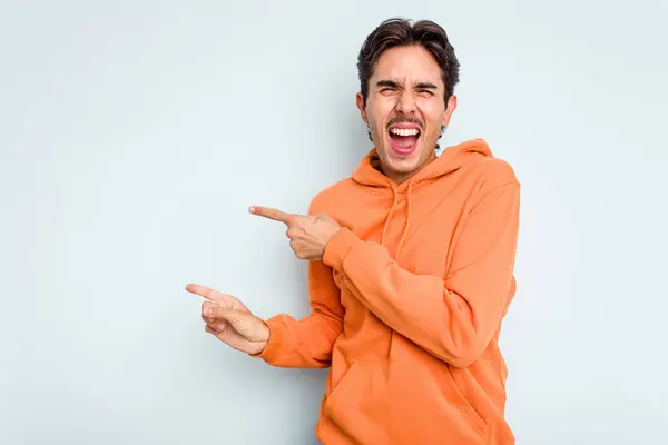 Young Hispanic Man Isolated Blue Background Pointing Forefingers Copy Space — стоковое фото