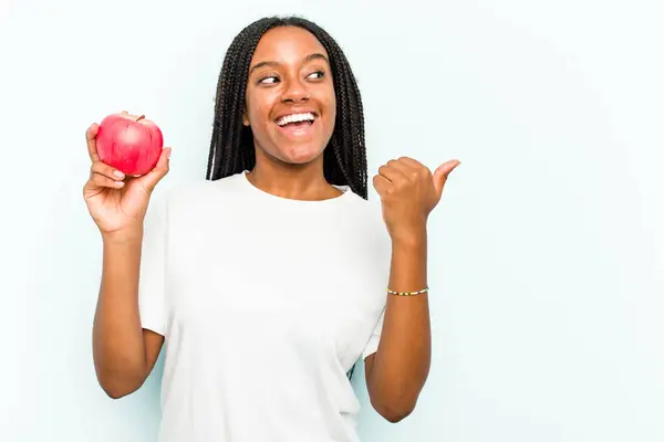 Ung Afroamerikansk Kvinna Håller Ett Äpple Isolerat Blå Bakgrundspunkter Med — Stockfoto