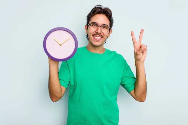 Jovem Hispânico Segurando Relógio Isolado Fundo Branco Mostrando Número Dois — Fotografia de Stock