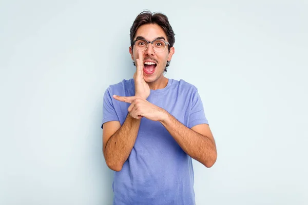 Young Hispanic Man Isolated Blue Background Saying Gossip Pointing Side — стоковое фото