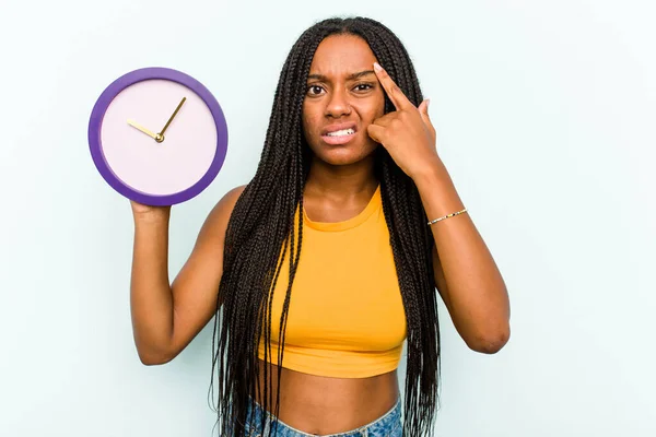 Ung Afroamerikansk Kvinna Håller Klocka Isolerad Blå Bakgrund Visar Besvikelse — Stockfoto