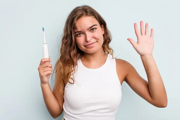 Elinde Elektrikli Diş Fırçası Olan Beyaz Bir Kadın Mavi Arka — Stok fotoğraf