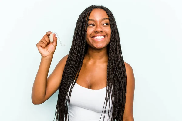 Young African American Woman Holding Hearing Aid Isolated Blue Background — Stock Photo, Image