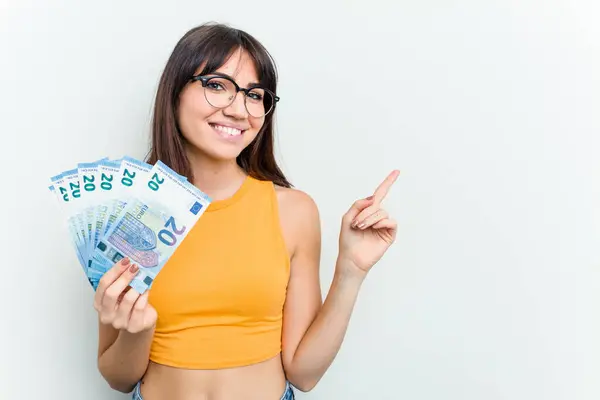 Young Caucasian Woman Holding Banknotes Isolated Blue Background Smiling Pointing — Stock Photo, Image