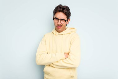 Mavi arka planda izole edilmiş genç bir İspanyol. Sıkılmış, yorgun ve dinlenmeye ihtiyacı var..