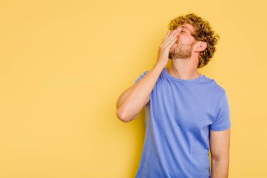 Sarı arka planda izole edilmiş genç beyaz adam gülüyor, kaygısız, doğal duygu..