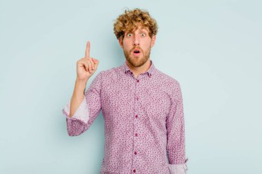 Mavi arka planda izole edilmiş beyaz bir adam ağzı açık bir şekilde üst tarafı işaret ediyor..
