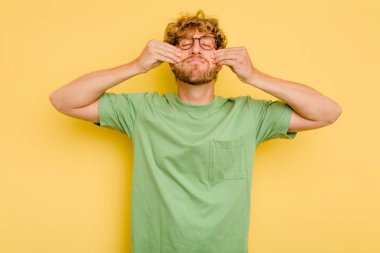 Kafkasyalı genç, sarı arka planda izole edilmiş, iki seçenek arasında şüphe duyuyor..