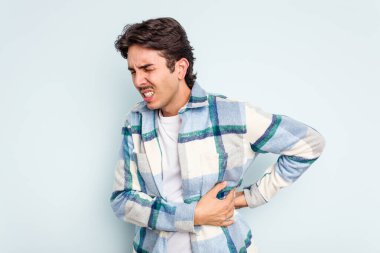 Mavi arka planda karaciğer ağrısı ve karın ağrısı çeken genç bir İspanyol..