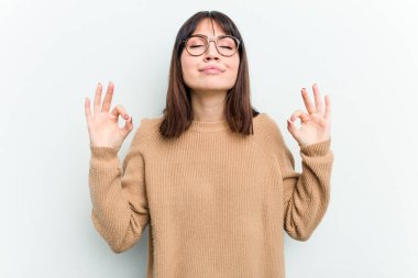 Beyaz arka planda izole edilmiş genç beyaz kadın sıkı çalışma gününden sonra rahatlıyor, yoga yapıyor..