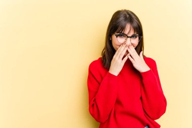 Kafkasyalı genç bir kadın sarı arka planda izole edilmiş bir plan kuruyor, bir fikir kuruyor..