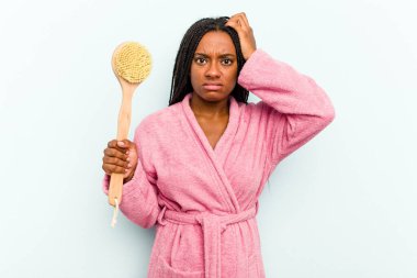 Mavi arka planda izole edilmiş küvet fırçası tutan genç Afrikalı Amerikalı kadın şok geçiriyordu. Önemli bir toplantıyı hatırladı..