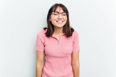 Beyaz arka planda izole edilmiş genç beyaz kadın gülüyor ve gözlerini kapıyor, rahatlamış ve mutlu hissediyor..