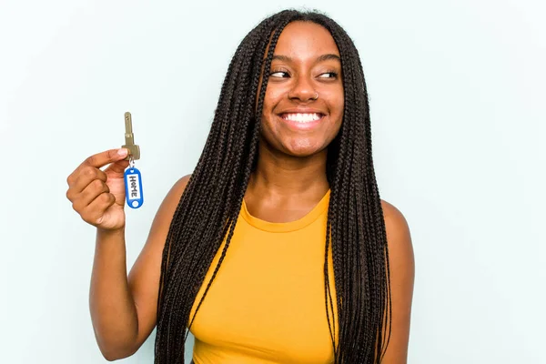 Mladá Afroameričanka Drží Domácí Klíče Izolované Modrém Pozadí Dívá Stranou — Stock fotografie