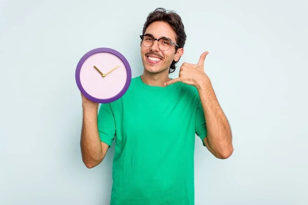 Jovem Hispânico Segurando Relógio Isolado Fundo Branco Mostrando Gesto Chamada — Fotografia de Stock