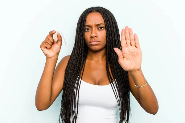 Mujer Afroamericana Joven Sosteniendo Audífono Aislado Sobre Fondo Azul Pie —  Fotos de Stock