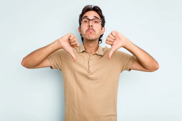 Young Hispanic Man Isolated Blue Background Showing Dislike Gesture Thumbs — стоковое фото