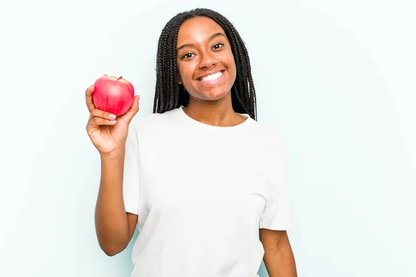Mavi Arka Planda Izole Edilmiş Bir Elma Tutan Genç Afrikalı — Stok fotoğraf