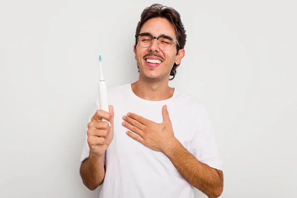 Joven Hispano Sosteniendo Cepillo Dientes Eléctrico Aislado Sobre Fondo Blanco —  Fotos de Stock