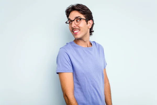 Young Hispanic Man Isolated Blue Background Looks Aside Smiling Cheerful — Stock Photo, Image