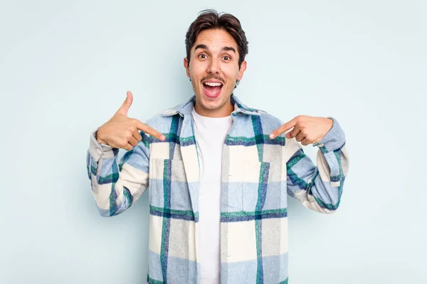 Young Hispanic Man Isolated Blue Background Surprised Pointing Finger Smiling — Stock Photo, Image