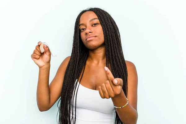Ung Afroamerikansk Kvinna Håller Hörapparat Isolerad Blå Bakgrund Pekar Med — Stockfoto