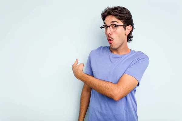 Joven Hombre Hispano Aislado Sobre Fondo Azul Sonriendo Señalando Lado — Foto de Stock