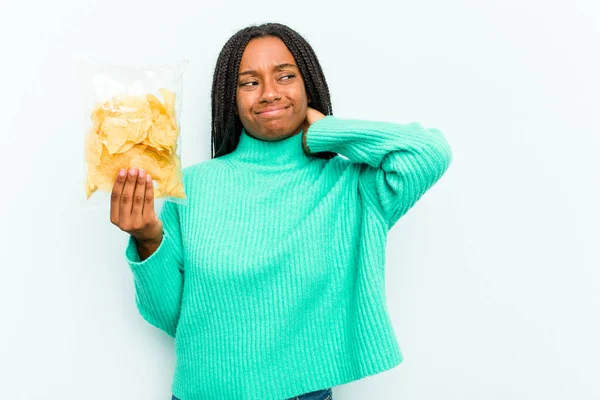 Junge Afroamerikanerin Hält Kartoffelchips Isoliert Auf Blauem Hintergrund Und Berührt — Stockfoto