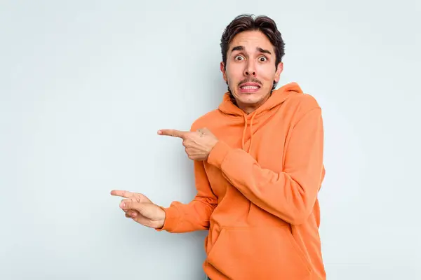 Young Hispanic Man Isolated Blue Background Shocked Pointing Index Fingers — стоковое фото