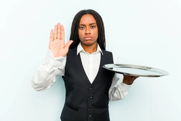 Młoda Afroamerykańska Kelnerka Trzymająca Tacę Niebieskim Tle Stojąca Wyciągniętą Dłonią — Zdjęcie stockowe