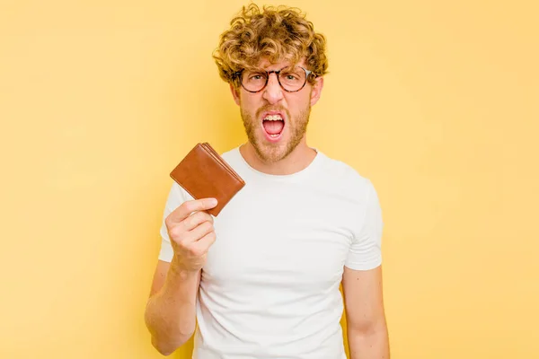 Young Caucasian Man Holding Wallet Isolated Yellow Background Screaming Very — Stock Photo, Image