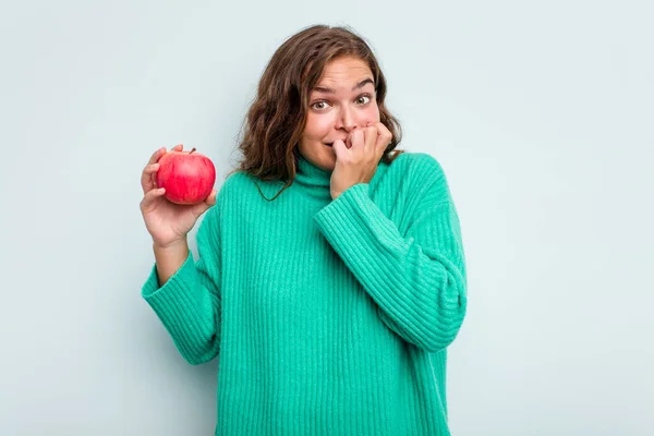 Mujer Joven Caucásica Con Una Manzana Aislada Sobre Fondo Azul — Foto de Stock