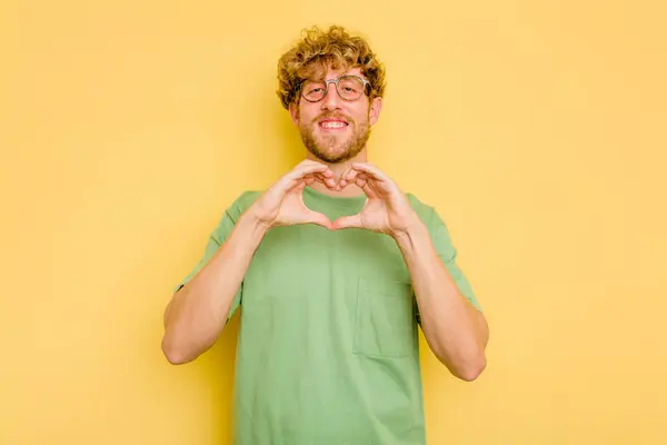 Jonge Blanke Man Geïsoleerd Gele Achtergrond Glimlachend Toont Een Hartvorm — Stockfoto