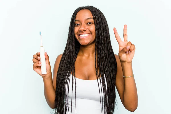 Young African American Woman Holding Electric Toothbrush Isolated Blue Background — Stock Photo, Image